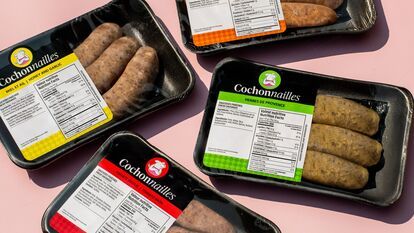 Packaged Cochonnailles sausages, colorful labels in yellow, red, green, and orange, flavors honey and garlic, herbes de Provence, tomato basil, arranged on pink background, top view.
