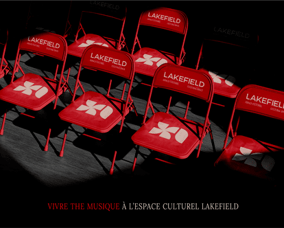 Photographie en plongée de plusieurs chaises pliantes rouges disposées en rangées sur un plancher sombre. Chaque chaise est marquée du logo de l’Espace culturel Lakefield : l’icône florale blanche stylisée sur l’assise, et le mot-symbole LAKEFIELD accompa