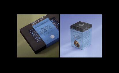 Two product packages from La Maison du Bleuet. On the left, a black box with a window showing dark chocolate covered blueberries, with the text 